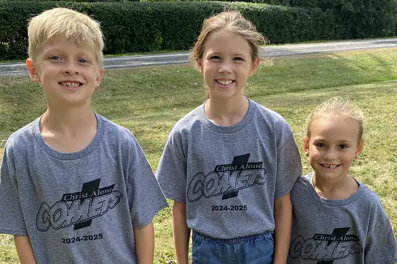 3 CALS students in gray shirts outside on a sunny day