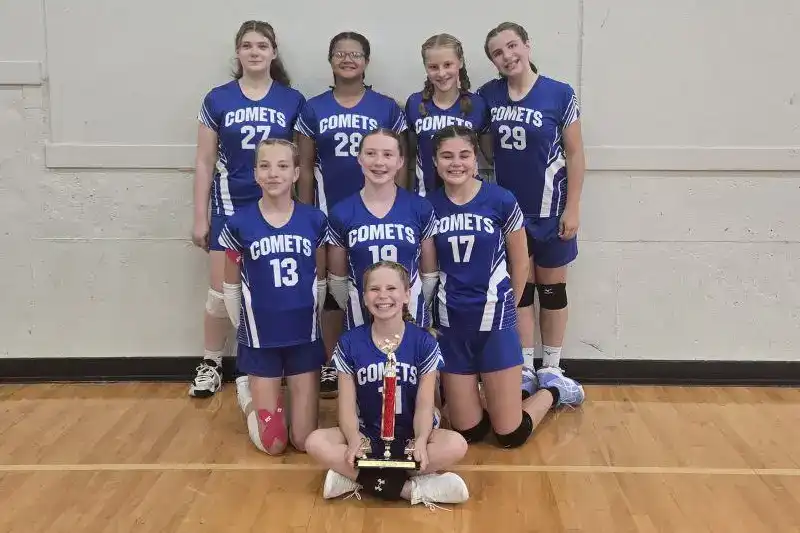girls volleyball team with trophy